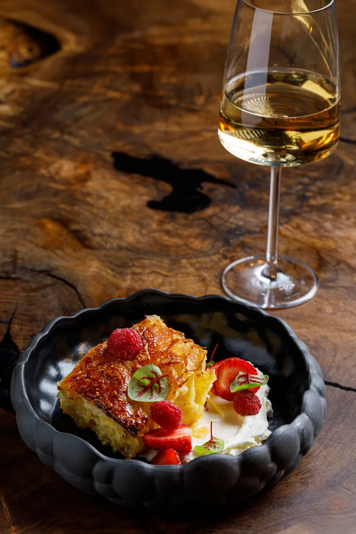Orange banitsa with berries and a glass of white wine